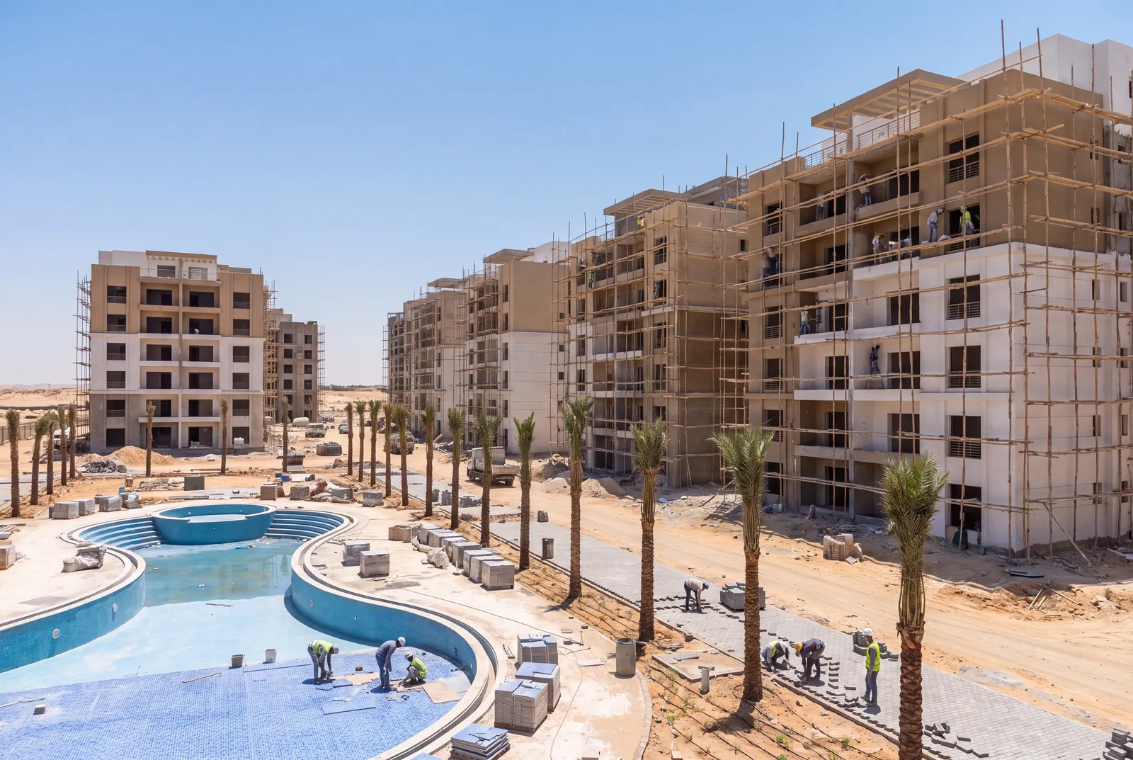 Apartment compound in the finishing stage with pool tiling and palms